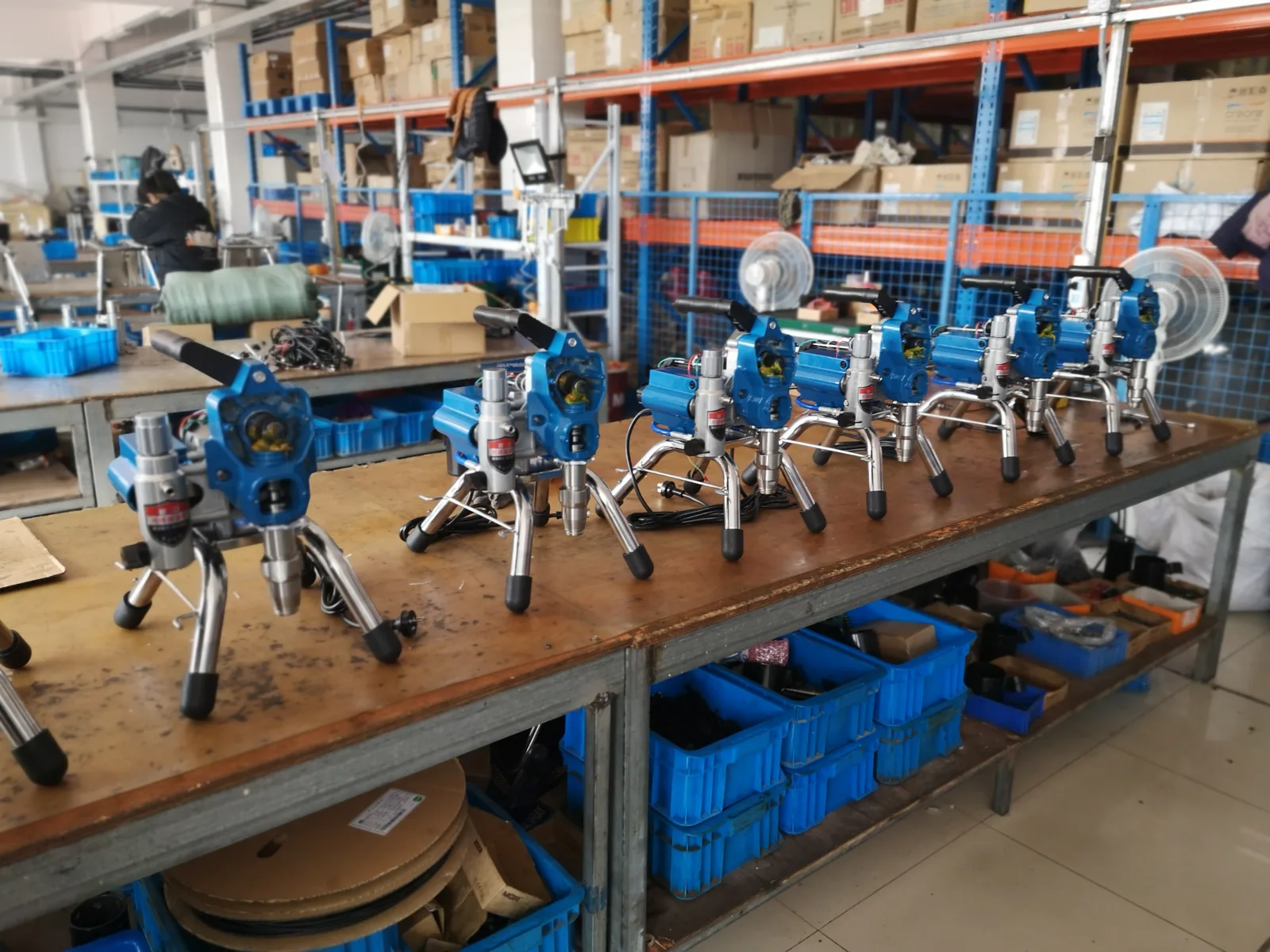 Airless paint sprayers and components on assembly benches in the Nantong workshop