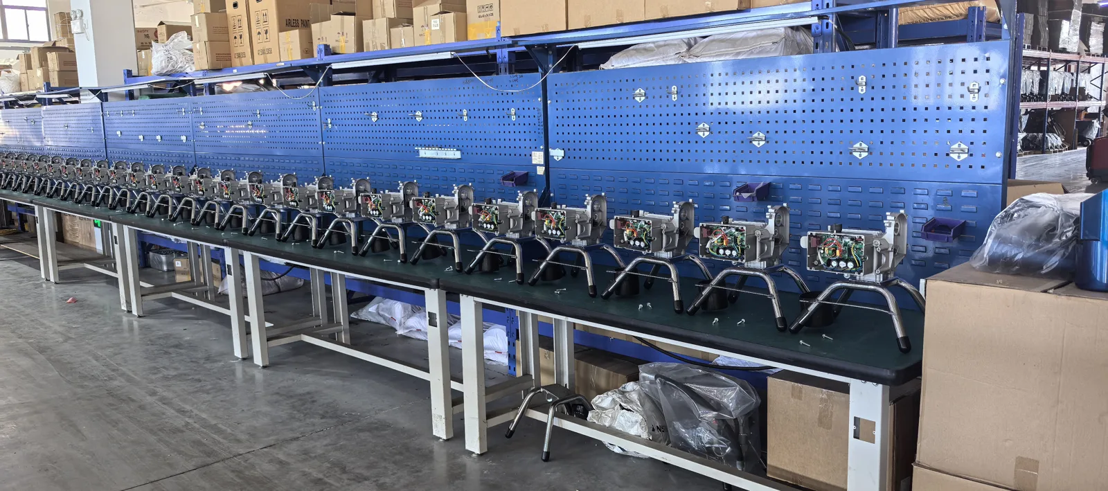 Spray equipment components arranged along assembly benches in the Taizhou workshop